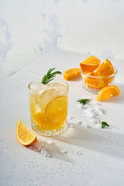 Portakal suyu veya biberiyeli kokteyl ve buzlu portakal suyu, açık gri kayrak, taş ya da beton arka planda soğuk yaz limonatası. Derin güneş gölgeli plaj konsepti. Üst görünüm.