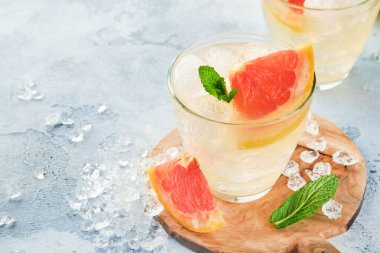 Limonata, greyfurt, soda ve nane yapraklarından yapılmış açık mavi kayrak, taş ya da beton zemin üzerinde buz. Sağlıklı ev yapımı limonata veya kokteyl. Model yap. Üst görünüm.