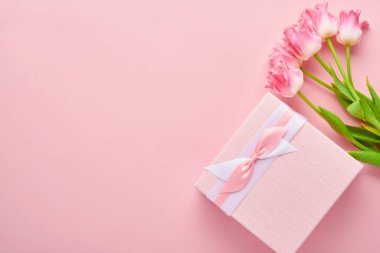 Paskalya tebrik kartı, paskalya çöreği yumurtaları hediye paketi ve pembe arka planda lale çiçekleri. Üst görünüm düzlüğü kopyalama alanı ile yatıyordu