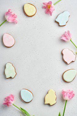 Paskalya sofrasında çiçek dekoru ve beyaz masada paskalya zencefilli ekmek. Zarif bir akşam yemeği. Model yap. Üst görünüm.