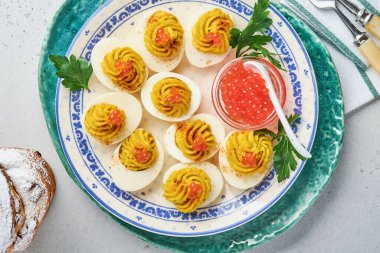 Kırmızı havyarlı yumurta dolması ve aperatif Paskalya masası için kırmızı biber tabağı, üst manzara, fotokopi alanı. Mutlu Paskalyalar için geleneksel yemek.