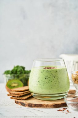 Lahana, ıspanak ve kiviyle detoks yeşil smoothie açık gri kayrak, taş veya beton arka plan. Kopyalama alanı olan üst görünüm.