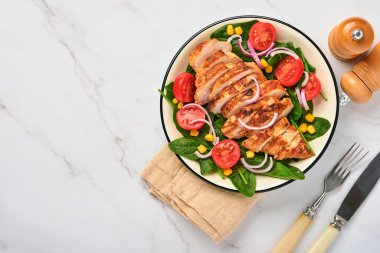 Salata ıspanaklı tavuk filetosu, kiraz domatesleri, çiçek ve soğan. Sağlıklı yiyecekler. Keto diyeti, diyet öğle yemeği konsepti. Beyaz arkaplanda üst görünüm.