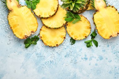 Açık mavi taş zemin üzerinde dilimlenmiş olgun ananas. Tropik meyveler. Üst Manzara. Metin için boş alan. Model.