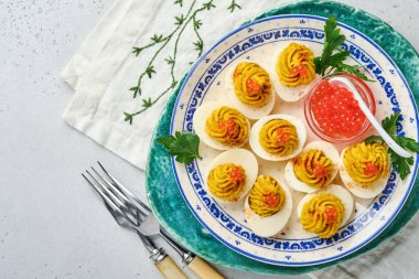 Kırmızı havyarlı yumurta dolması ve aperatif Paskalya masası için kırmızı biber tabağı, üst manzara, fotokopi alanı. Mutlu Paskalyalar için geleneksel yemek.