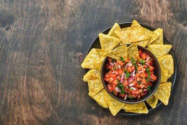 Geleneksel Meksika domates sosu. Nacho, domates, sarımsak, soğan ve ahşap kaplama. Latin Amerika ve Meksika yemekleri kavramı. Model.