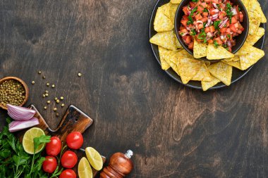 Geleneksel Meksika domates sosu. Nacho, domates, sarımsak, soğan ve ahşap kaplama. Latin Amerika ve Meksika yemekleri kavramı. Model.