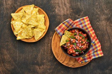 Geleneksel Meksika domates sosu. Nacho, domates, sarımsak, soğan ve ahşap kaplama. Latin Amerika ve Meksika yemekleri kavramı. Model.