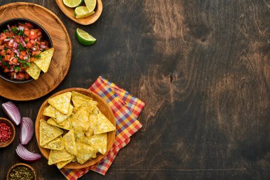 Geleneksel Meksika domates sosu. Nacho, domates, sarımsak, soğan ve ahşap kaplama. Latin Amerika ve Meksika yemekleri kavramı. Model.