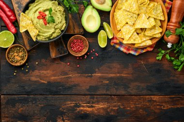 Guacamole. Geleneksel Latin Amerika Meksika sos siyah bir kâse içinde avokado, malzemeler ve mısır cipsi. Avokado yayılımı. Üst Manzara. Boşluğu kopyala.