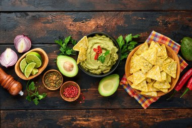 Guacamole. Geleneksel Latin Amerika Meksika sos siyah bir kâse içinde avokado, malzemeler ve mısır cipsi. Avokado yayılımı. Üst Manzara. Boşluğu kopyala.