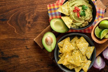 Guacamole. Geleneksel Latin Amerika Meksika sos siyah bir kâse içinde avokado, malzemeler ve mısır cipsi. Avokado yayılımı. Üst Manzara. Boşluğu kopyala.