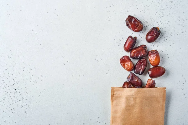 Dried sliced date fruit in paper bag on white background with copy space. Snack vegan sugarfree food — Stock Photo, Image