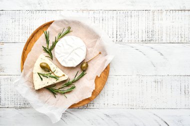 Set ya da çeşitli peynirler. Camembert peyniri, biberiyeli krem peynir, kapari ve biber. Üst Manzara. Beyaz ahşap arka planda. Boş kopyalama alanı.