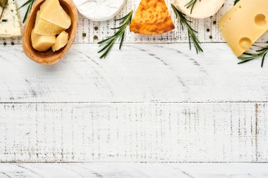 Set ya da çeşitli peynirler. Baharatlı suluguni, camembert, mavi peynir, parmesan, maasdam, biberiyeli brie peyniri ve biber. Üst Manzara. Beyaz ahşap arka planda. Boş kopyalama alanı.