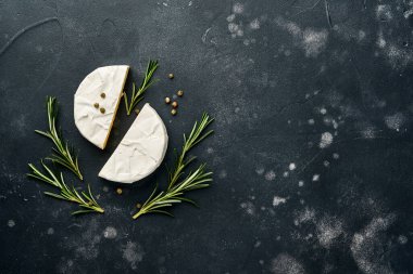 Biberiyeli peynirli camembert peyniri, kapari ve biber. Eski siyah arka planda. Üst Manzara. Metnin için boş yer.