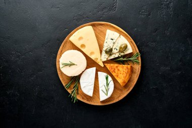 Set ya da çeşitli peynirler. Baharatlı suluguni, camembert peyniri, ricotta, maasdam, brie peyniri. Üst Manzara. Siyah arka planda. Boş kopyalama alanı.