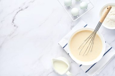 Kahvaltı ya da Maslenitsa için ev krepleri için hamur hazırlama. Masadaki malzemeler - buğday unu, yumurta, tereyağı, şeker, tuz, süt. Adım adım tarif et. Metin için yeri olan üst görünüm.