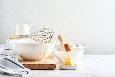 Kahvaltı ya da Maslenitsa için ev krepleri için hamur hazırlama. Masadaki malzemeler - buğday unu, yumurta, tereyağı, şeker, tuz, süt. Adım adım tarif et. Seçici odak.