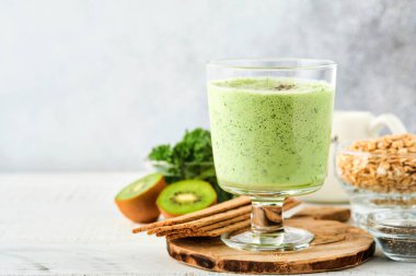 Lahana, ıspanak ve kiviyle detoks yeşil smoothie açık gri kayrak, taş veya beton arka plan. Kopyalama alanı olan üst görünüm.