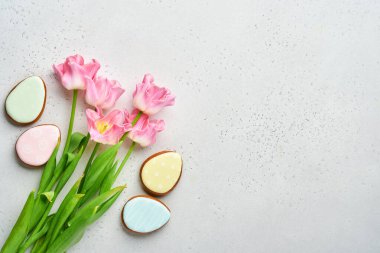 Paskalya sofrasında çiçek dekoru ve gri masada paskalya zencefilli ekmek. Zarif bir akşam yemeği. Model yap. Üst görünüm.