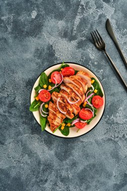 Salata ıspanaklı tavuk filetosu, kiraz domatesleri, çiçek ve soğan. Sağlıklı yiyecekler. Keto diyeti, diyet öğle yemeği konsepti. Beyaz arkaplanda üst görünüm.