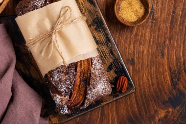 Tarçınlı muzlu ekmek ve hafif beton zemin üzerine krema serpiştirilmiş şeker. Seçici odak, metin için alan