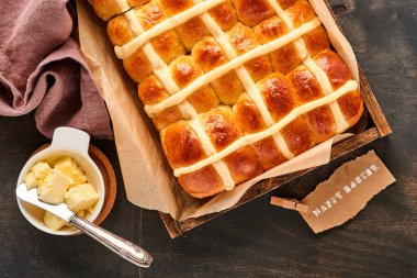 Paskalya Sıcak Çörekleri. Geleneksel kahvaltı ve Paskalya pastası dekorasyonu. Tavşanlar, eski, karanlık ahşap arka plan. Parlak renkler, yukarıdan ahşap masa manzarası.