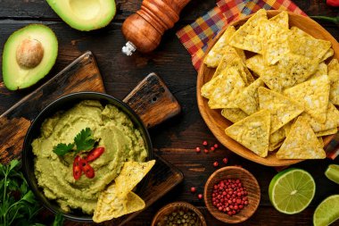 Guacamole. Geleneksel Latin Amerika Meksika sos siyah bir kâse içinde avokado, malzemeler ve mısır cipsi. Avokado yayılımı. Üst Manzara. Kopyalama alanı