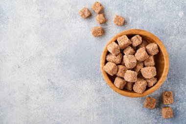 Çubuk şeker küpü, gri masa beton arka planında bambu kasesinde. Üst görünüm.