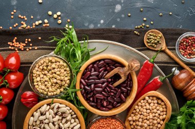 Legumes, mercimek, nohut, fasulye çeşitleri, siyah masada sağlıklı mutfak yapmak için lezzetli iştah açıcı baharatlar. Kilo verme diyeti ve kolesterol kavramına karşı savaş. Üst görünüm.