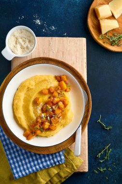 Tereyağlı, balkabaklı, sarımsaklı, tuzlu ve parmesan peynirli, koyu mavi beton arka planda. Geleneksel İtalyan yemekleri, vejetaryen yemekleri. Üst Manzara. Boşluğu kopyala.