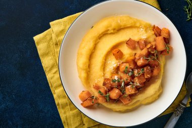 Tereyağlı, balkabaklı, sarımsaklı, tuzlu ve parmesan peynirli, koyu mavi beton arka planda. Geleneksel İtalyan yemekleri, vejetaryen yemekleri. Üst Manzara. Boşluğu kopyala.