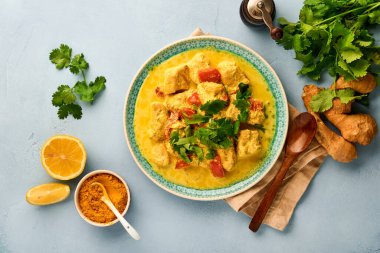 Tavuk tikka masala. Geleneksel Hint mutfağı körisi ve koyu arka planda malzemeler. Köri, kireç, zencefil, kişniş, biber, pirinç, şifalı otlar ve baharatlar. Kopyalama alanı olan üst görünüm.