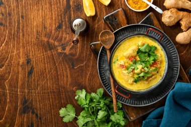 Tavuk tikka masala. Geleneksel Hint mutfağı körisi ve koyu arka planda malzemeler. Köri, kireç, zencefil, kişniş, biber, pirinç, şifalı otlar ve baharatlar. Kopyalama alanı olan üst görünüm.