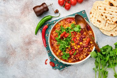 Meksika siyah fasulye çorbası, kıyma, domates, kişniş, avokado ve sebze güveci açık gri kayrak, taş veya beton arka planda. Geleneksel Meksika yemeği. Kopyalama alanı olan üst görünüm.