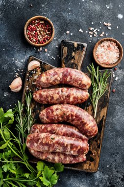 Çiğ sosis ya da baharat ve yemek pişirmek için malzemelerle kesilmiş sosis. Taş tablo üzerinde kopyalama alanı olan üst görünüm.