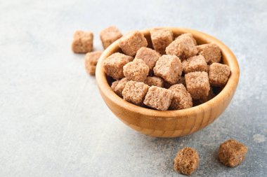 Çubuk şeker küpü, gri masa beton arka planında bambu kasesinde. Üst görünüm.