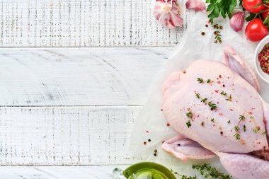 Biber, limon, kekik, sarımsak, kirazlı domates, sorrel ve tuz yapımında kullanılan malzemelerle dolu çiğ tavuk açık gri kayrak, taş ya da beton zemin üzerinde. Kopyalama alanı olan üst görünüm