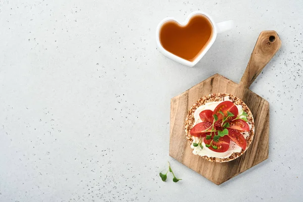 Krem peynirli, kırmızı turplu, domatesli ve mikroyeşilli karabuğday ekmekli glüten, gri taşlı arka planda sağlıklı bir kahvaltı. Yukarıdan bak. Vejetaryen ve sağlıklı beslenmeyi düşün..