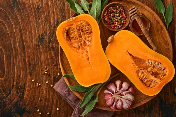 Adaçayı yapraklı çiğ organik tereyağlı kabak, çok renkli sarımsak, bal, tuz ve biber. Yemek arkaplanı. Kopyalama alanı olan üst görünüm.