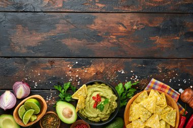 Guacamole. Geleneksel Latin Amerika Meksika sos siyah bir kâse içinde avokado, malzemeler ve mısır cipsi. Avokado yayılımı. Üst Manzara. Kopyalama alanı