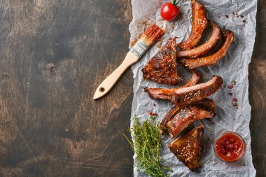 Eski bir ahşap kesme tahtasının üzerinde ızgara ve füme domuz pirzolası ve barbekü sosu. Lezzetli atıştırmalıklardan biraya. Resmi yaklaştır.