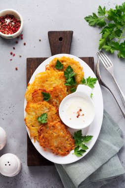 Draniki - patates kızartması, vejetaryen patatesli gözleme, taze otlar ve sarımsaklı yoğurt sosu ile servis edilmiş,