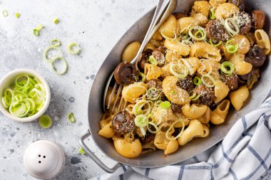 Pipa Rigate ve Mantar Şampiyonu 'nu soya sosunda kızartıp biber, parmesan peyniri ve eski bir masada eski bir metal kasede buğulanmış soğan yapıştırın. Seçici odak