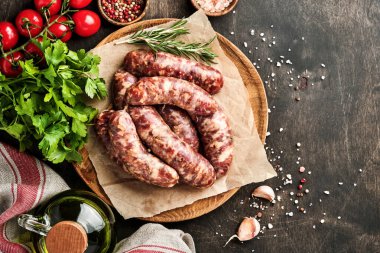 Çiğ sosis ya da parşömen kağıdına sosis ve yemek malzemesi. Taş tablo üzerinde kopyalama alanı olan üst görünüm.