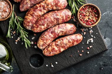 Çiğ sosis ya da baharat ve yemek pişirmek için malzemelerle kesilmiş sosis. Taş tablo üzerinde kopyalama alanı olan üst görünüm.