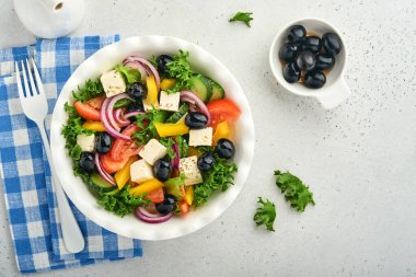 Geleneksel Yunan salatası, salatalık, domates, tatlı biber, marul, kırmızı soğan, beyaz tabakta zeytin yağlı beyaz peynir ve zeytin yağı. Sağlıklı yemek, en iyi manzara..