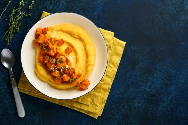 Tereyağlı, balkabaklı, sarımsaklı, tuzlu ve parmesan peynirli, koyu mavi beton arka planda. Geleneksel İtalyan yemekleri, vejetaryen yemekleri. Üst Manzara. Boşluğu kopyala.