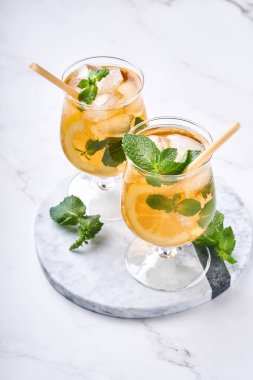 Geleneksel buzlu çay, limon ve buzlu uzun bardaklarda mermer masa üzerinde buzlu limonlu çay. Seçici odaklanma. Soğuk yaz içeceği..